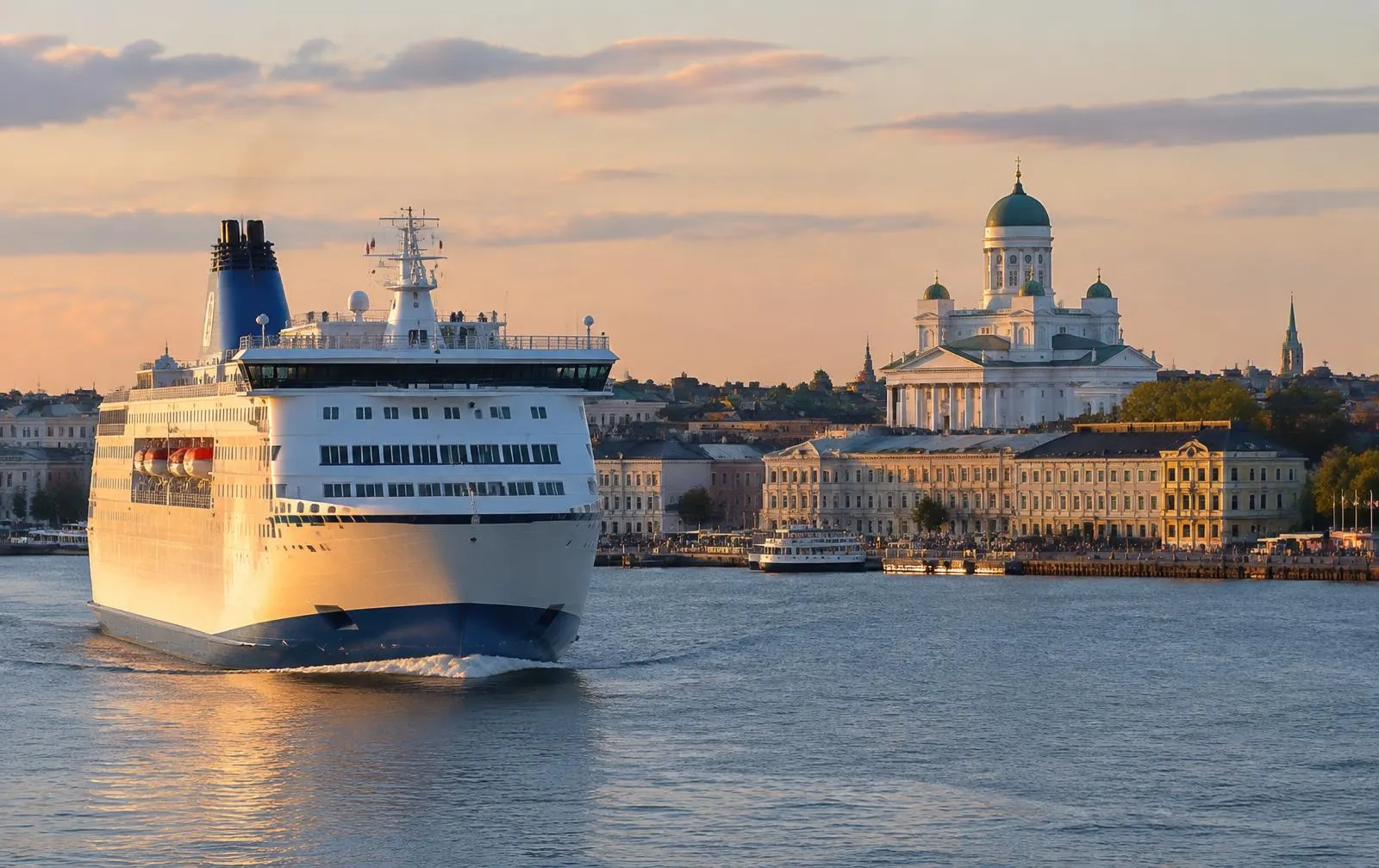Ferry approaching a harbour with a domed cathedral